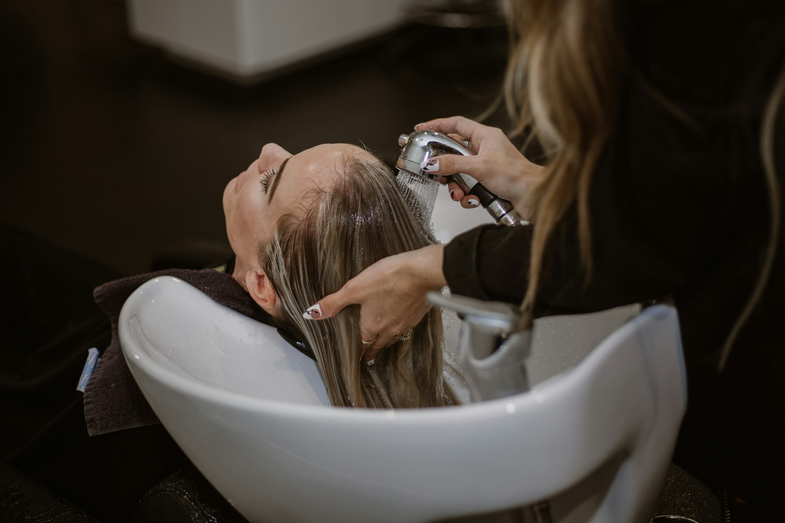 Kapper die het haar van een klant knipt in de salon